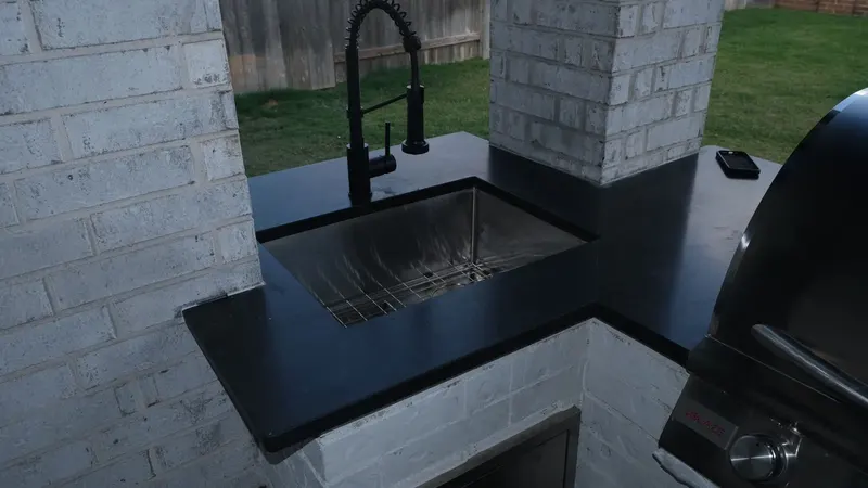 Undermount outdoor sink in the black granite countertop