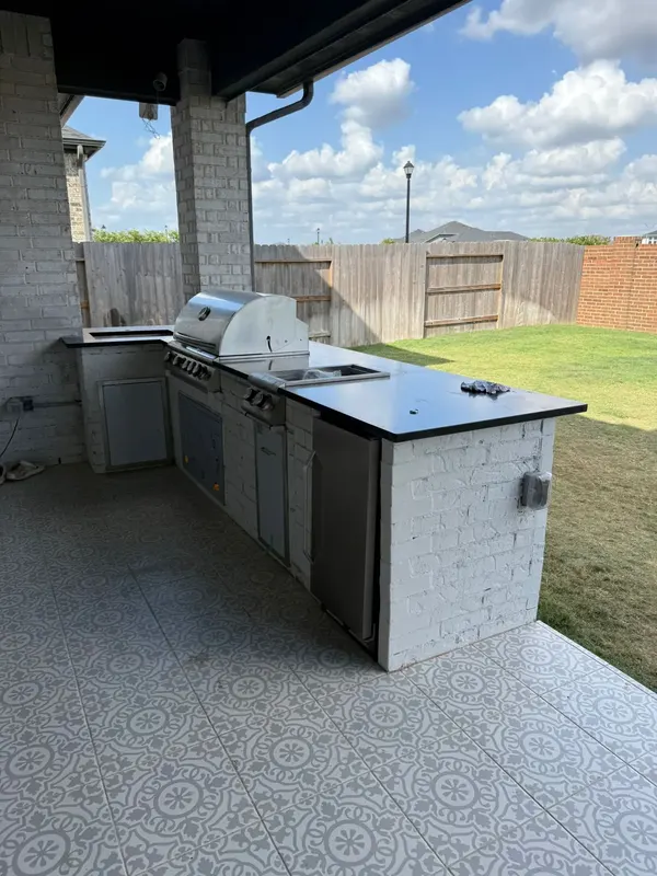 Finished outdoor kitchen from the yard with the Cypress fence behind