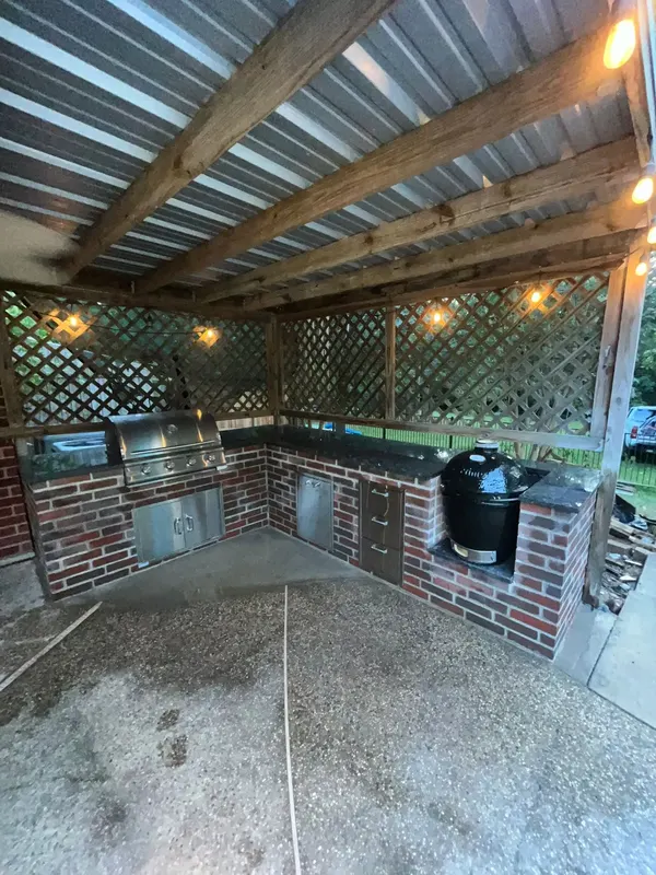 Brick outdoor kitchen with black granite counters under the covered patio, Regal Hill Ct, Montgomery TX