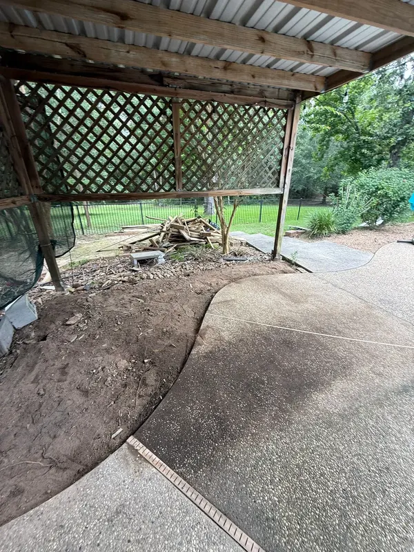 Before: bare patio slab under the lattice-sided cover
