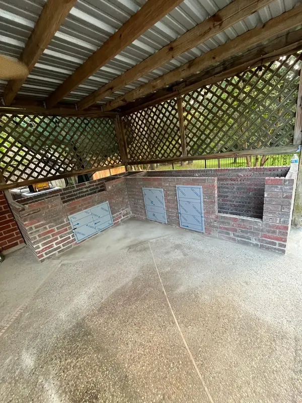 Brick walls with framed openings for the grill and doors