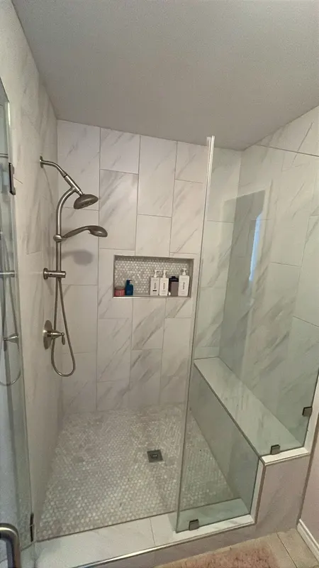 Shower fixtures and niche with toiletries after the remodel
