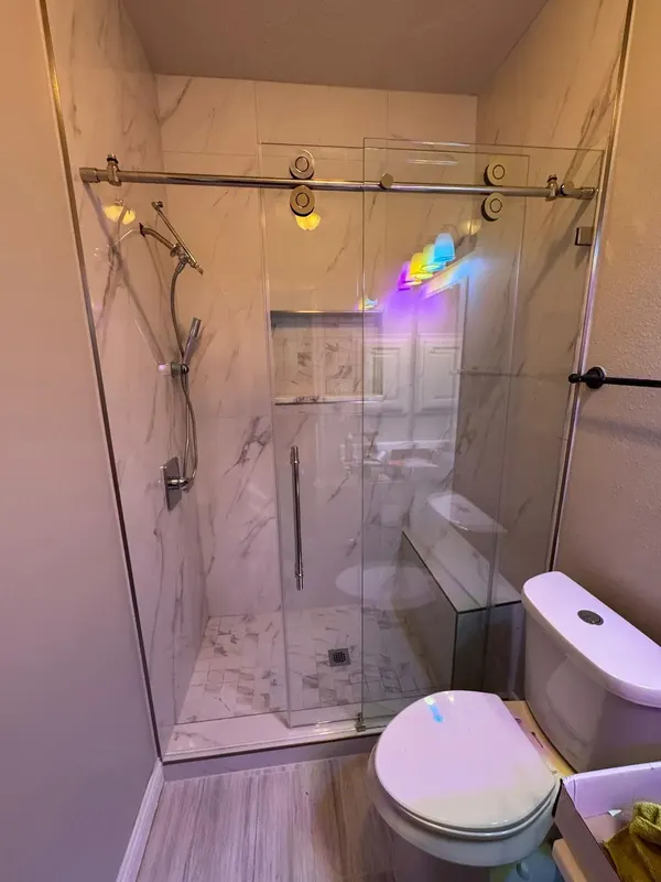 Marble-look tile shower with bench, niche and frameless glass, Drake Springs Ln, Pearland TX